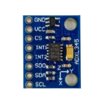 Compact blue ADXL345 accelerometer PCB featuring an onboard ultra-low-dropout regulator, filtering capacitors, pull-up resistors, and 8 clearly labeled circular solder pads for pin headers.