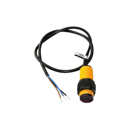 Industrial M18 cylindrical plastic-housed photoelectric sensor in bright orange/yellow, displaying dual black structural securing rings, a dark-colored infrared lens window on its face, and a thick black 3-wire cable breakout at the rear end with stripped wire leads.